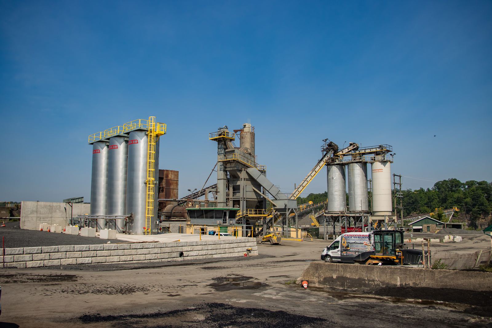 Asphalt production plant with storage silos under blue sky