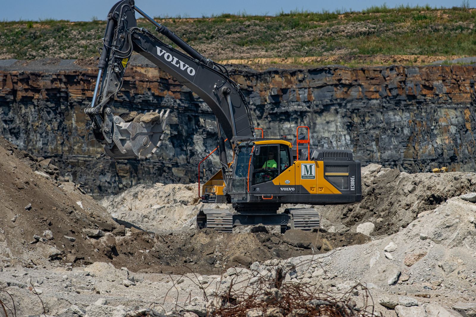 Volvo EC380EL excavator working the quarry floor against a highwall