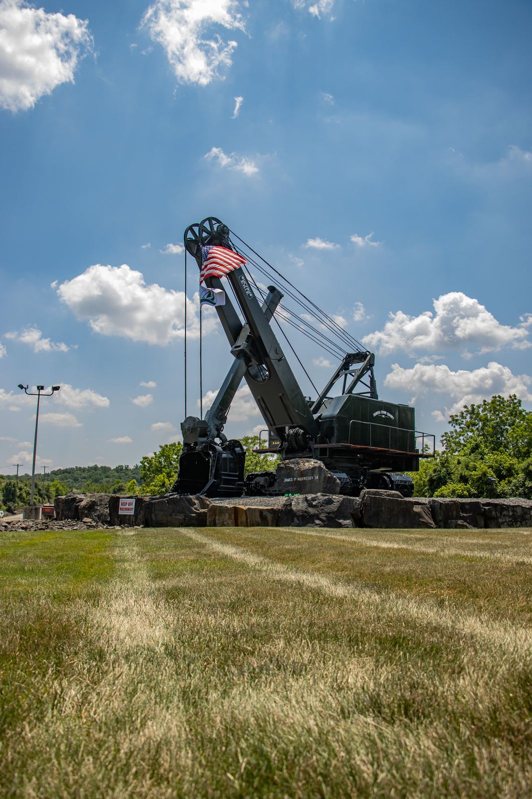 Restored heritage cable shovel displayed with American flag at quarry entrance
