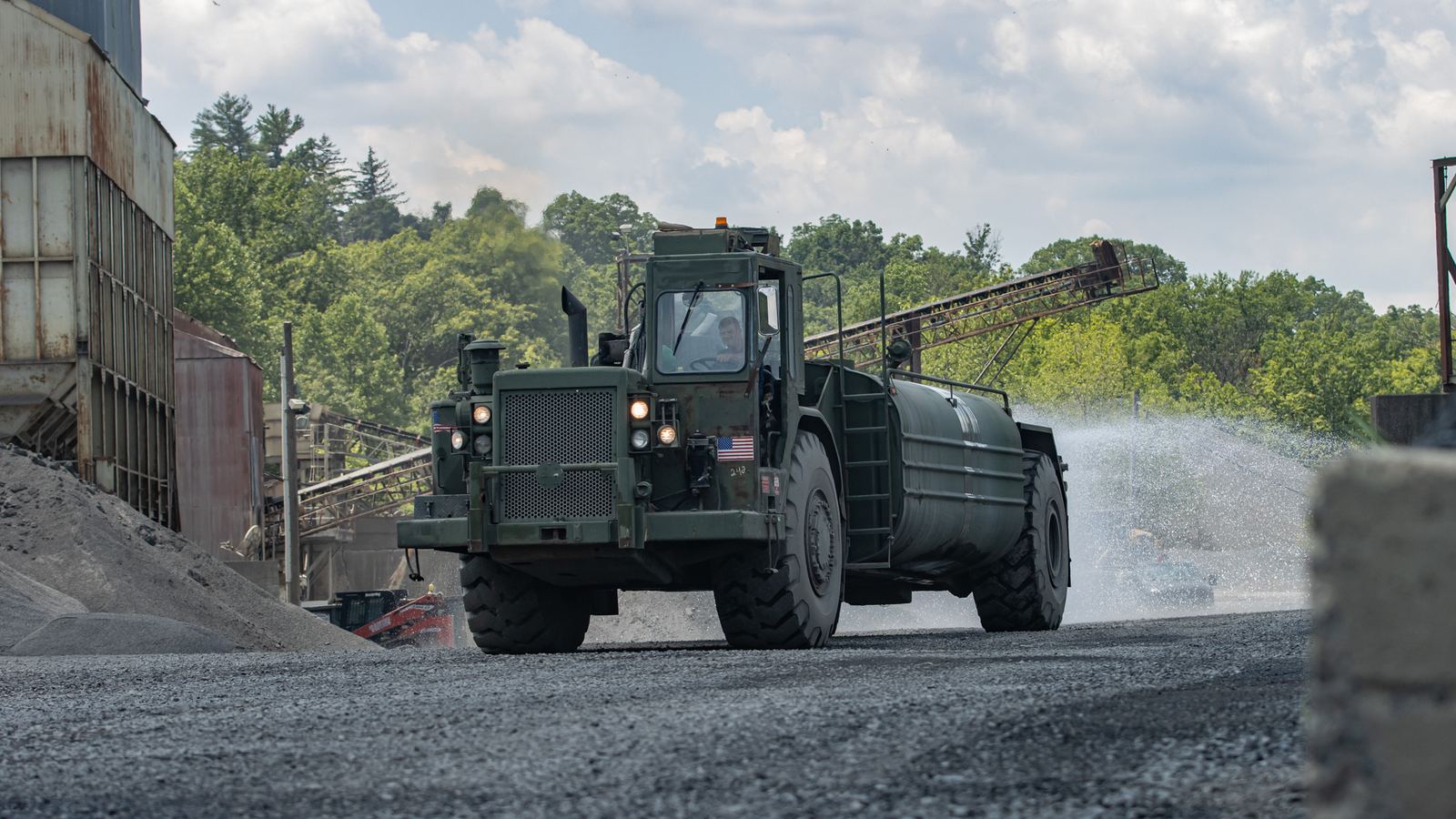 Water truck spraying a quarry haul road for dust control